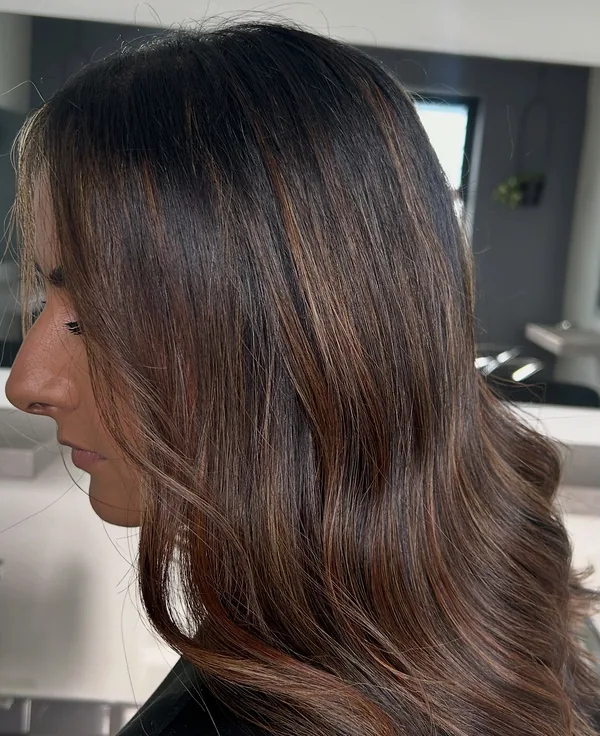 Shoulder-length chestnut brown balayage, seen in profile